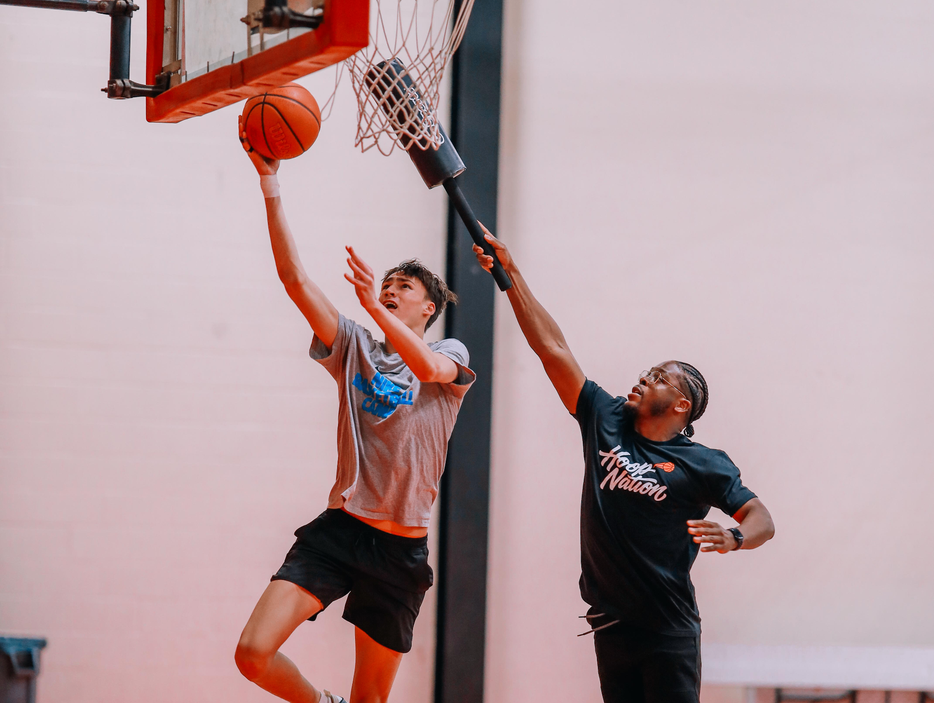 Coach working with a young player on finishing at the rim